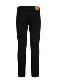 Černé džíny z denimu s úzkým střihem, které mají dvě zadní kapsy, hnědou koženou nášivku v pase a hladkou strukturu.