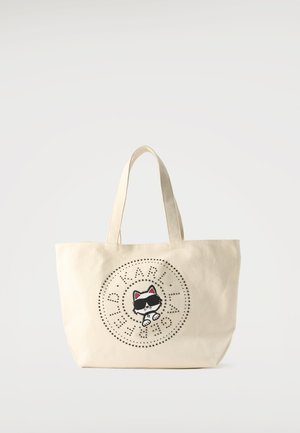 Beige draagtas met korte handvatten, met een zwart-witte kat die een zonnebril draagt, omringd door een design van gegolfde tekst in een cirkelpatroon.