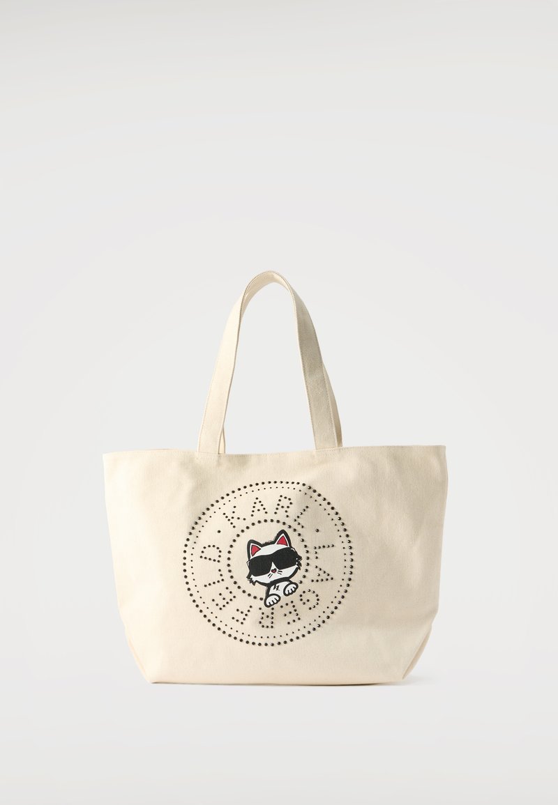 Μπεζ τσάντα tote με κοντά χερούλια που απεικονίζει μια ασπρόμαυρη γάτα με γυαλιά ηλίου, περιβαλλόμενη από κυκλικό μοτίβο με κουκκίδες και κείμενο.