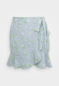 Květinová zavinovací sukně z světle modré látky, zdobená zelenými a bílými květinami, s volánkovým lemem a zavazováním v pase.