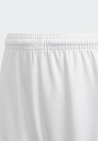 Pantalones cortos deportivos blancos con cinturilla elástica, textura suave y un ligero brillo, con un corte holgado y sin patrones visibles.