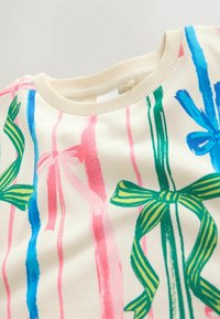 Helle beigefarbene Sweatshirt mit buntem Druck in Form von vertikalen Streifen in Pink, Blau und Grün sowie bogenförmigen Akzenten in verschiedenen Farben.