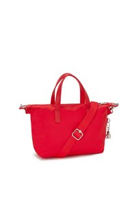 Red nylon tote bag with dual top handles, detachable shoulder strap, zip closure, and side charm detail. Smooth texture with a structured shape.