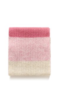 Écharpe en tricot présentant un design dégradé dans des tons de rose et de crème, surface texturée avec une apparence douce et confortable, soigneusement pliée.