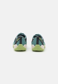 Sko til sport med mesh-overdel i teal og sort, med en grøn såle og hælflik, designet for komfort og stabilitet.