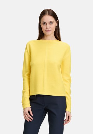 Gelber Pullover mit strukturierter Strickart, Rundhalsausschnitt und geradem Saum. Verfügt über lange Ärmel mit Knopfdetails an den Manschetten.