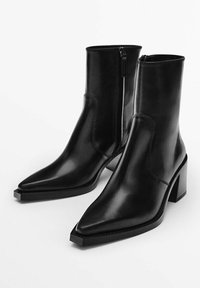 Stivaletti alla caviglia in pelle nera con punta affilata, zip laterale e tacco a blocco spesso. Presentano una texture liscia e elegante con cuciture minime.