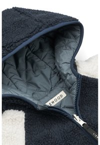 Navy-Fleece-Jacke mit kontrastierendem cremefarbenem Innenfutter. Verfügt über ein gestepptes Futter, silbernen Reißverschluss und ein Markenetikett im Inneren der Kapuze.