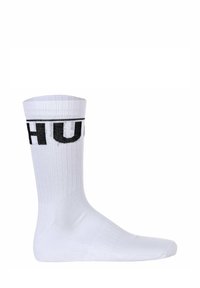 Calzino sportivo bianco in cotone con trama a coste, presenta il logo "HUF" ricamato in nero sul bordo. Design a livello della caviglia con punta rinforzata.
