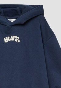 Granatowy hoodie wykonany z mieszanki bawełny, z dużym białym logo "SLVR" na klatce piersiowej oraz luźnym krojem z podszywanym kapturem.