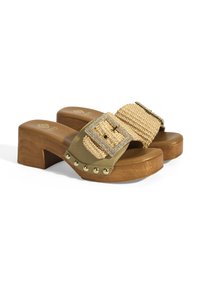 Olijfgroene klompen met een geweven band met een metalen gesp, houten hak en gouden studs langs de basis. Gladde textuur overal.