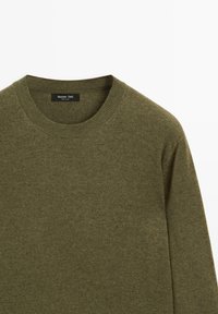 Maglione verde oliva con scollo rotondo, realizzato in morbido tessuto a maglia, con un'etichetta al colletto recante il testo "Massimo Dutti".