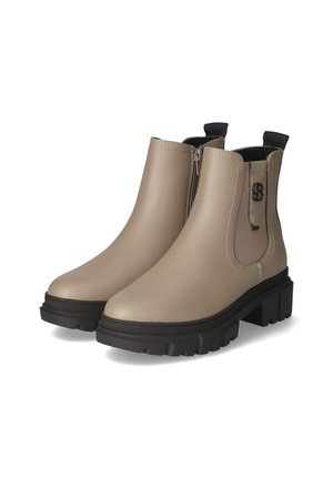 Botas de tobillo beige con un acabado de imitación cuero suave, paneles laterales elásticos y una suela negra gruesa. Presenta un pequeño logo en el lateral.