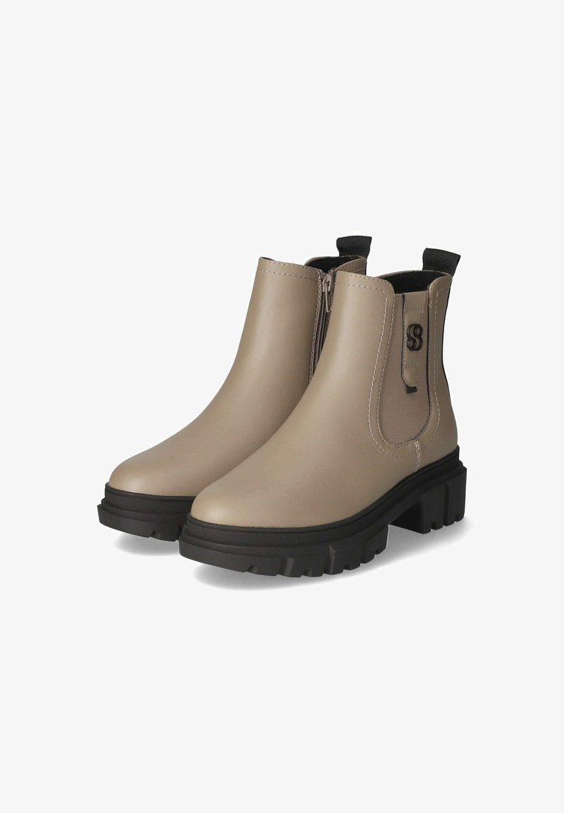 Bottes à la cheville beiges avec une finition en simili cuir lisse, des panneaux latéraux élastiques et une semelle noire épaisse. Présente un petit logo sur le côté.