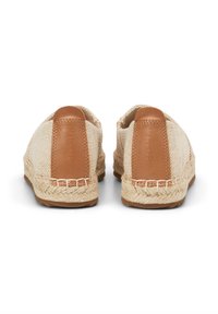 Espadrilles beige clair avec des accents en cuir tan, semelles en jute tressé et dessus en tissu texturé, avec un design cousu et un détail de logo.