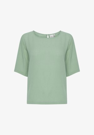 Lõdva istuvusega lühikeste varrukatega topp helesinisel tooni, ümarava ja selja taga võtmeaugu detailiga. Valmistatud siledast ja pehmest kangast.