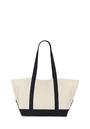 Beige canvas tas met zwarte handvatten en zwarte bodem, breed en ruim van formaat met lange schouderbanden voor gemakkelijk dragen.