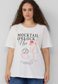 Witte katoenen t-shirt met korte mouwen, voorzien van een grafische print van een cocktailglas, tekst en oranje accenten. Ronde halslijn, relaxte pasvorm.
