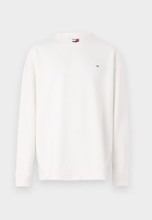 Balta džemperis ilgomis rankovėmis, apvaliu iškirpimu ir kanalėlių gaubtais. Mažas logotipas kairėje krūtinės pusėje raudonos, baltos ir mėlynos spalvos. Lygus paviršius.