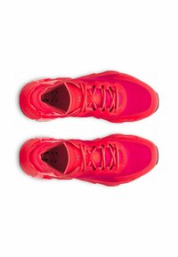 Bright pink athletic shoes with a textured upper, lacing system, and cushioned sole, featuring a distinctive pattern on the insole.