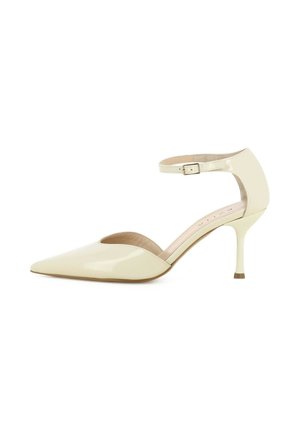 Cremefarbener Lackleder-Pumps mit spitzer Zehenpartie, Knöchelriemen und schlankem Stilettoabsatz auf weißem Hintergrund.