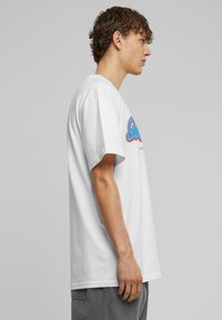 Hvid bomulds t-shirt med korte ærmer, featuring en farverig tekstdesign på fronten. Enkel rund halsudskæring, afslappet pasform og glat tekstur.