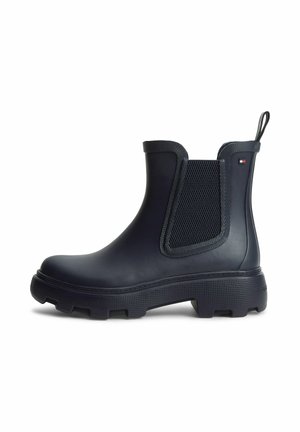 Schwarzer Chelsea-Gummistiefel mit klobiger Sohle, elastischen Seitenteilen, Zuglasche und kleinem rechteckigem Logo nahe dem Knöchel.