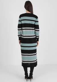 Robe à manches longues rayée avec des bandes horizontales alternant noir, sarcelle et argent, coupe droite et longueur mi-mollet.