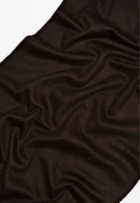 Tissu sombre et doux avec une texture lisse, présentant des plis fluides et un léger brillant, dans une riche teinte de brun.
