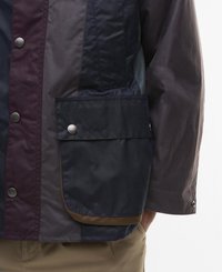 Wodoodporna kurtka w mixie kolorów granatowego i burgundowego, o teksturowanym wykończeniu, z zatrzaskami oraz przednią kieszenią oznaczoną napisem "Barbour."