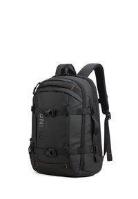 Zaino nero con una finitura testurizzata, multiple cinghie e fibbie, un grande scomparto principale e dettagli arancioni.