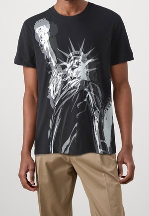 Camiseta negra con estampado gráfico de la Estatua de la Libertad en tonos grises, cuello redondo clásico, mangas cortas y ajuste holgado.