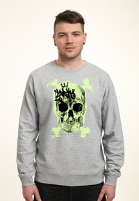 Šedá mikina s velkým neonově zeleným potiskem lebky a designem s lebkami v černé barvě. Vyrobena z měkké, texturované látky.