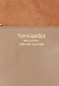 Portafoglio in pelle beige con superficie strutturata, recante il nome del marchio "NeroGiardini" in rilievo, e etichette che indicano "Made in Italy" e "Pelle autentica".