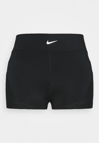 Shorts de sport noirs en tissu extensible avec un logo Nike blanc sur la ceinture et des détails côtelés sur les côtés.