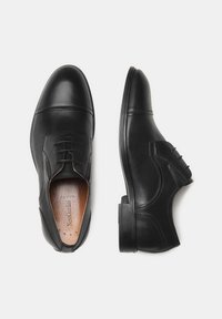 Schwarze Leder dress Schuhe mit runder Zehenform, schlichter Vorderseite mit Schnürsenkeln und dezenten Nähdetails an den Seiten und oben.