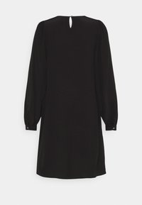 Robe noire à manches longues avec épaules bouffantes, poignets boutonnés et une petite ouverture en forme de goutte fermée par un bouton au niveau de l'encolure arrière.