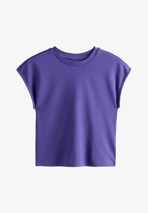 Violetinė trumpomis rankovėmis suapvalintu kaklu marškinėliai su laisvu siluetu ir šiek tiek užlenktais rankovių kraštais, pateikti ant balto fono.