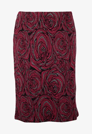 Czerwona spódnica o długości do kolan z kwiatowym wzorem, o gładkiej teksturze, zestawiona z czarnymi, kryjącymi rajstopami i botkami za kostkę, trzymająca czarną kopertówkę.