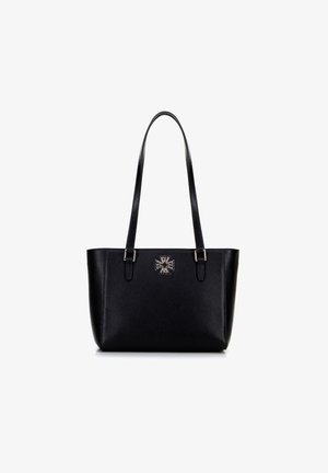 Zwarte, gestructureerde leren tote bag met lange handvatten en een centraal geplaatst zilverkleurig geometrisch logo aan de voorkant.