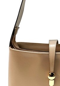 Sac à main synthétique beige avec une texture lisse, un design plat, des accents en métal doré et une bandoulière amovible.