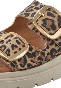 Leopard print platform sandals with two wide straps, large gold buckles, and a textured suede upper atop a chunky beige sole.