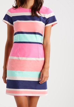 Frau trägt ein kurzärmeliges knielanges Kleid mit horizontalen Streifen in Pink, Marineblau, Hellblau und Weiß.