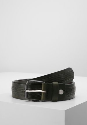 Black leather belt with textured pattern and silver buckle coiled on white surface against gray background.