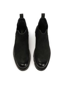 Botas de tobillo negras hechas de cuero y ante, con paneles laterales elásticos, puntera redondeada y tiradores para facilitar el uso. Acabado liso y mate.