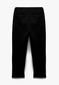 Pantalones de chándal negros con una cinturilla elástica, dos bolsillos traseros y una textura de tela suave, estrechándose en el tobillo con un corte ajustado.