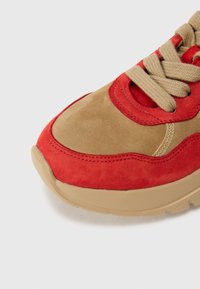 Baskets en daim rouges et beige avec une finition texturée, dotées de lacets beiges, d'un col rembourré et d'une semelle en caoutchouc chunky beige.