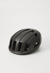 Cască de ciclism neagră cu o suprafață netedă, formă aerodinamică, multiple fante de ventilație și o bandă texturată de tip carbon fibra pe partea de sus.