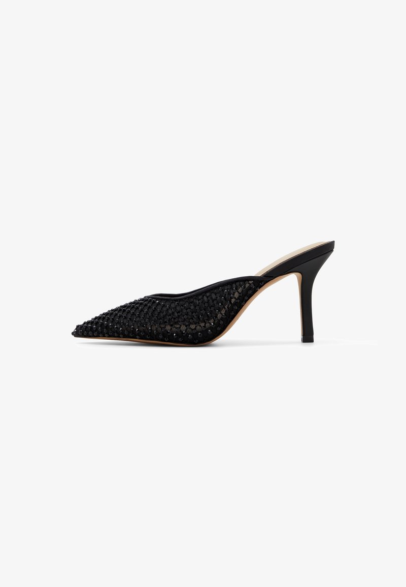 Mule noire à bout pointu avec talon stiletto haut et empeigne en tissu texturé avec petits points en relief.