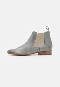 Bota Chelsea de cuero perforado gris con paneles elásticos beige a los lados, punta redondeada y un bajo tacón de madera. Incluye una lengüeta para facilitara ponerlas.